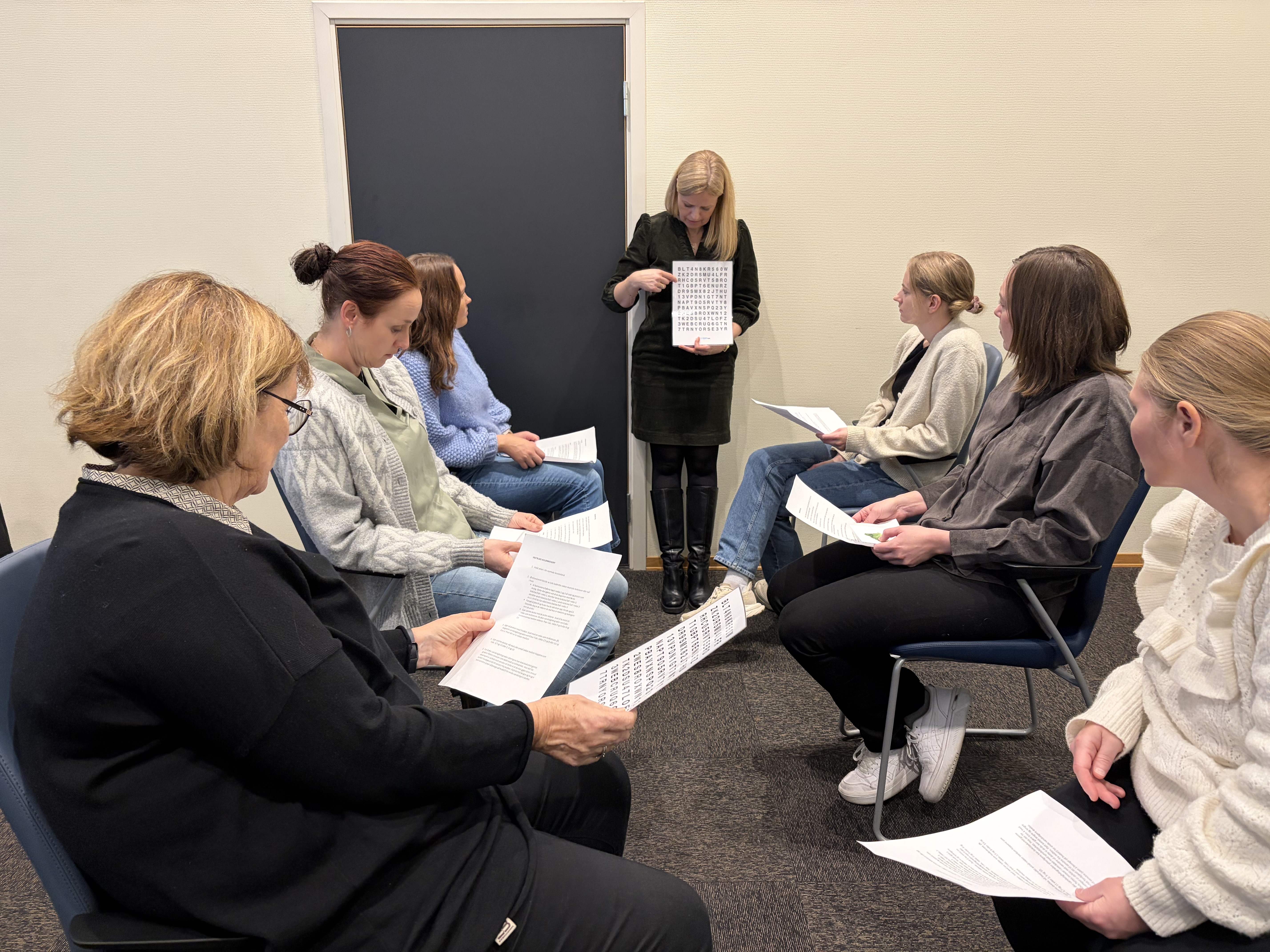 Workshop i synsrehabilitering hvor et av temaene var trening av øyemotorikk. Syv personer sitter i ring.