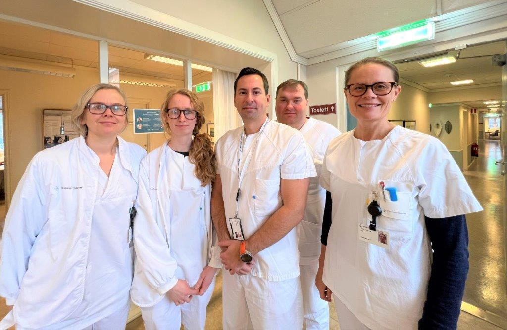 En gruppe mennesker iført hvite labfrakker og merker