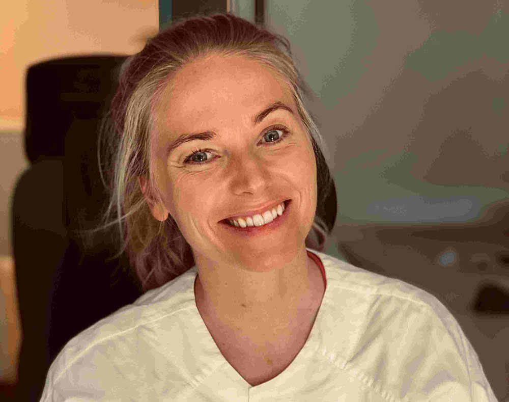 En kvinne som smiler til kameraet