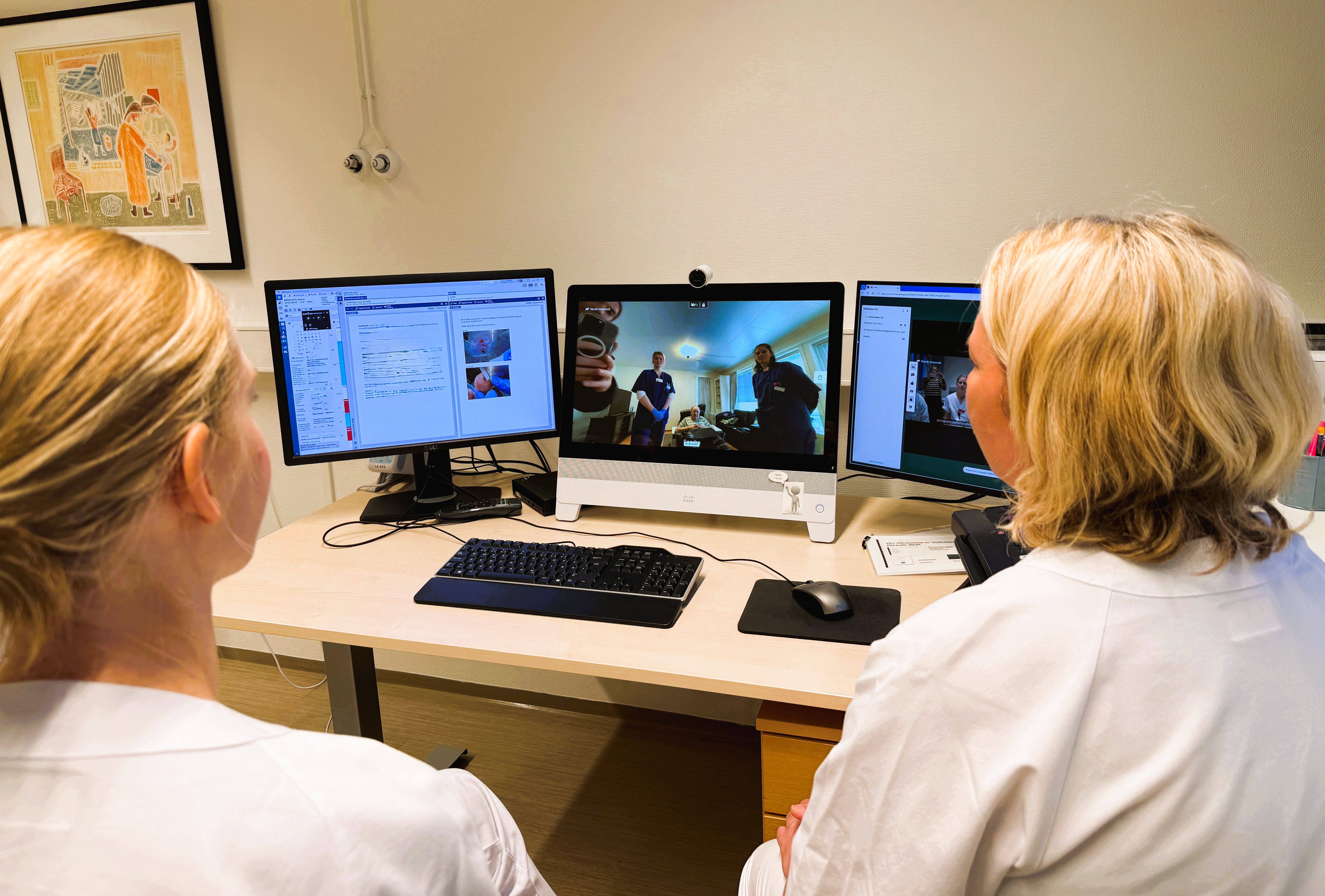 En person som sitter ved et skrivebord med en datamaskin og et tastatur