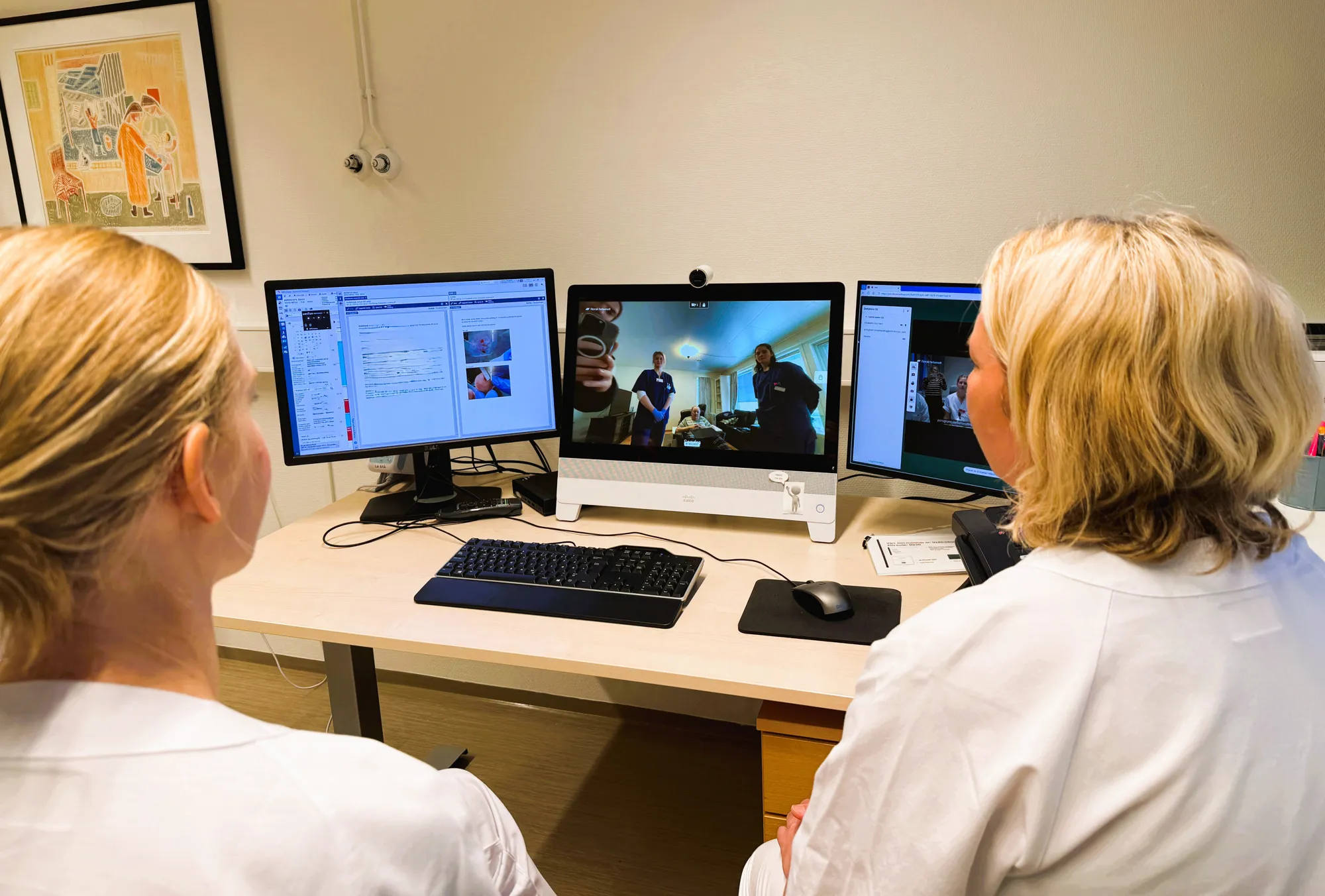 En person som sitter ved et skrivebord med en datamaskin og et tastatur