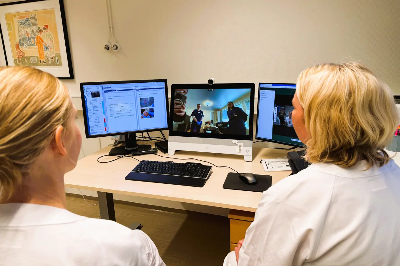 En person som sitter ved et skrivebord med en datamaskin og et tastatur