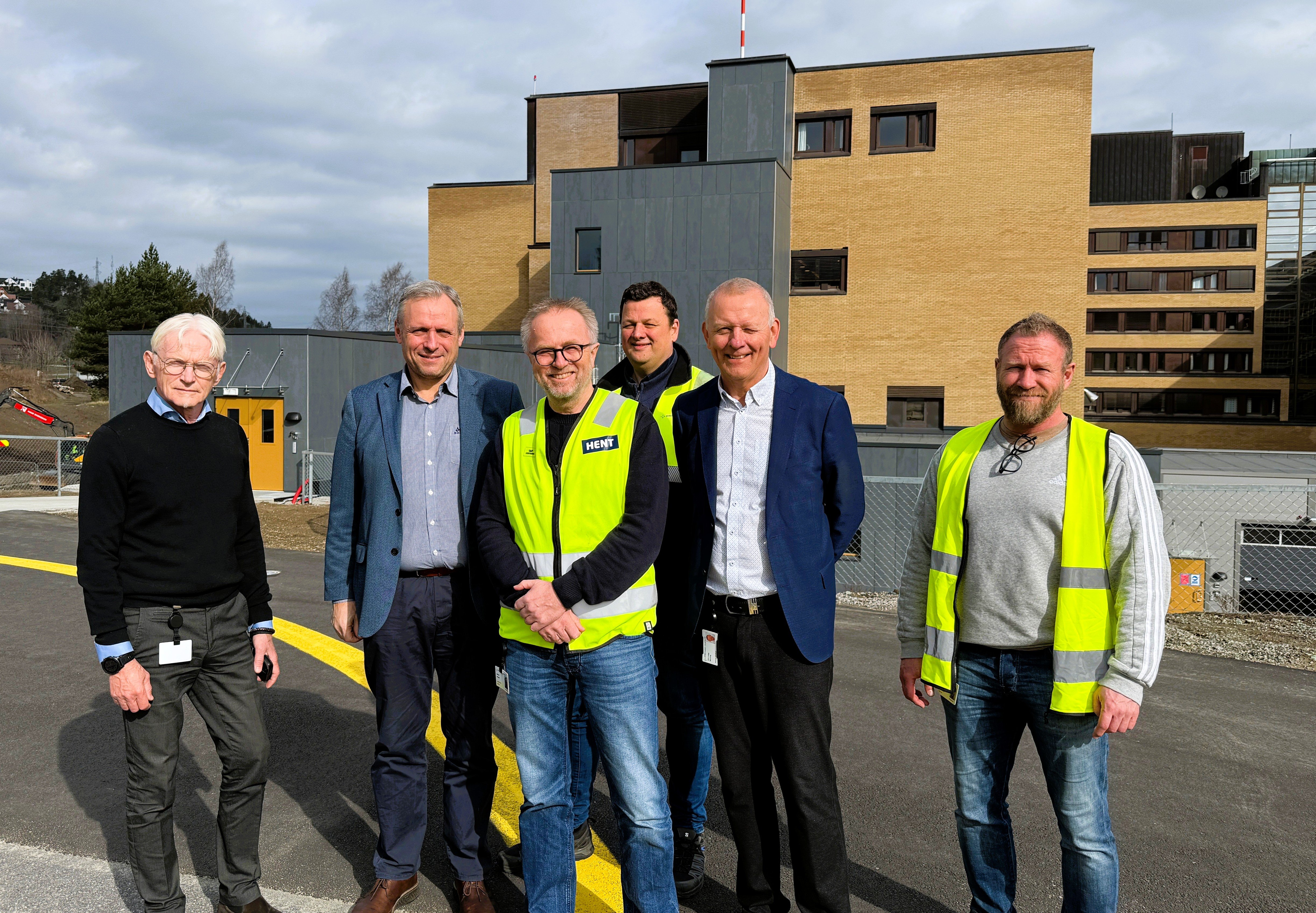 Christian Brødreskift, Morten Nilsen, Øyvind Haugen, Christian Borchgrevink Lund Andersen, Tom Helge Rønning og Owe Holm  på landingsplassen foran det nye akuttsenteret.