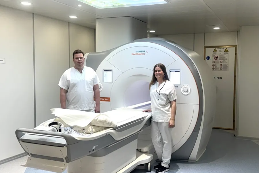 To ansatte ved Sykehuset står ved siden av en ny MR-maskin