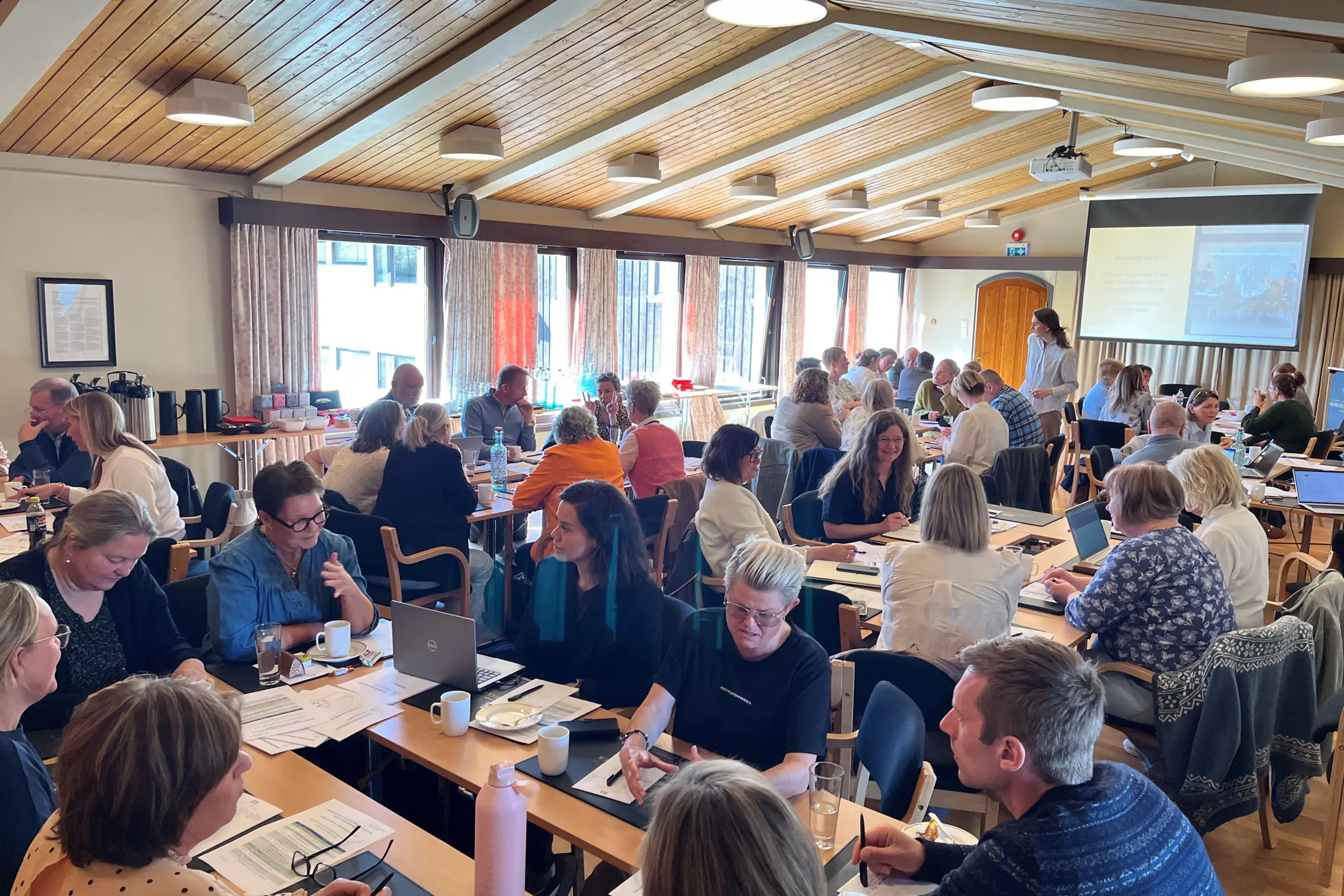 En gruppe mennesker som sitter ved bord