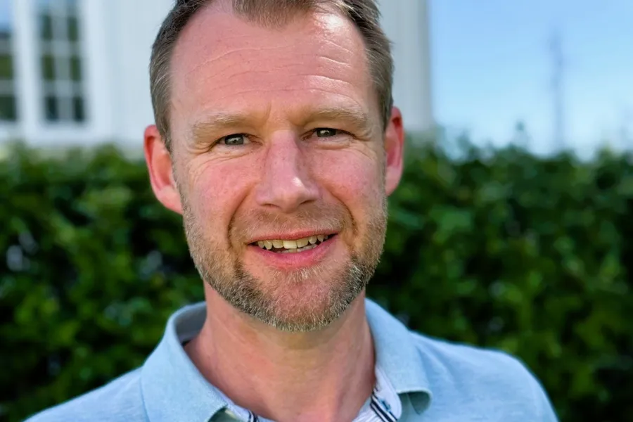 En mann som smiler til kameraet