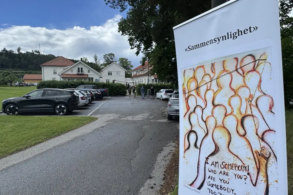 En plakat hvor det står sammensynlighet på, med bygg 10 i bakgrunn