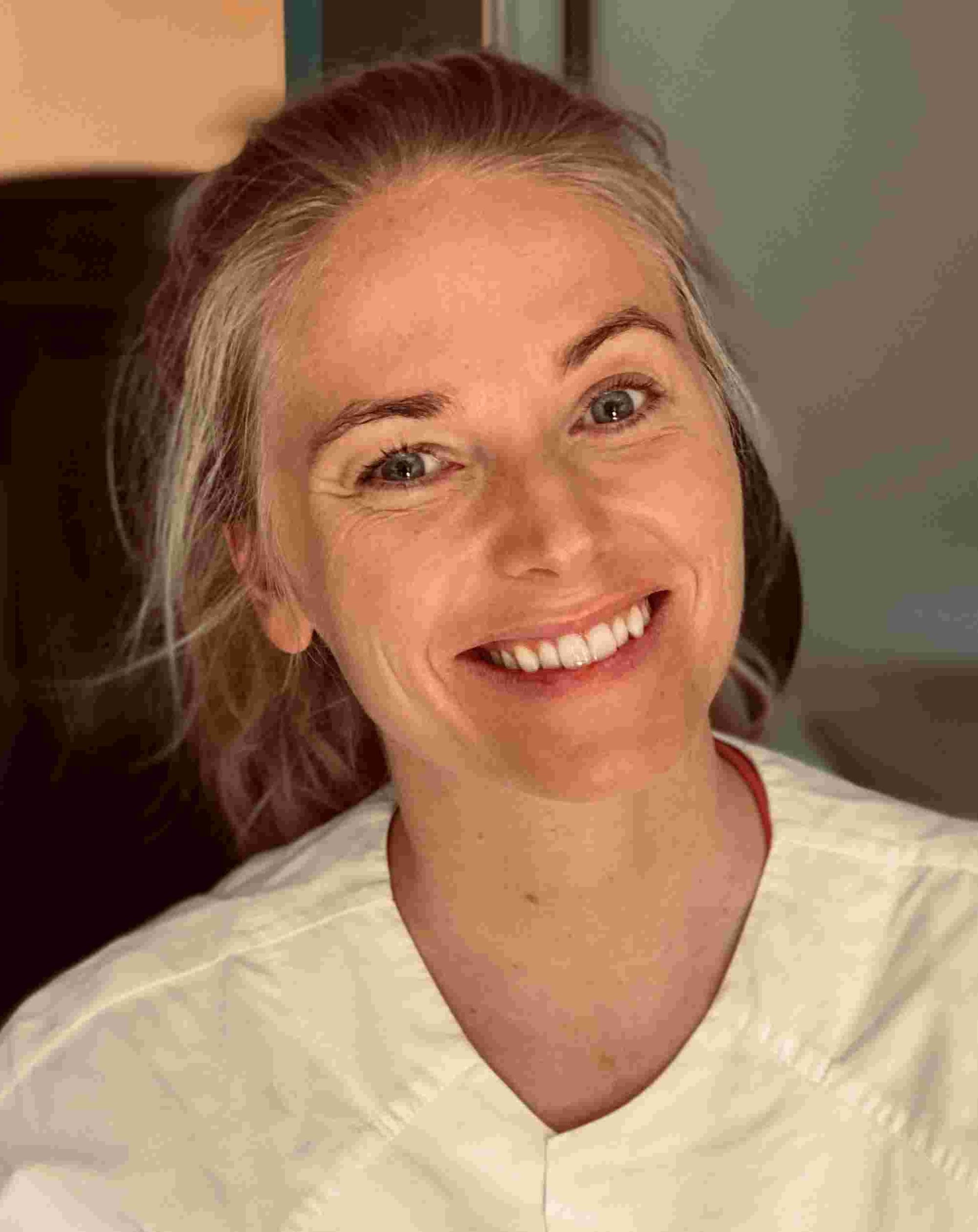 En kvinne som smiler til kameraet
