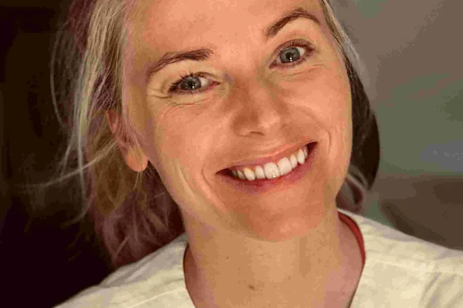 En kvinne som smiler til kameraet