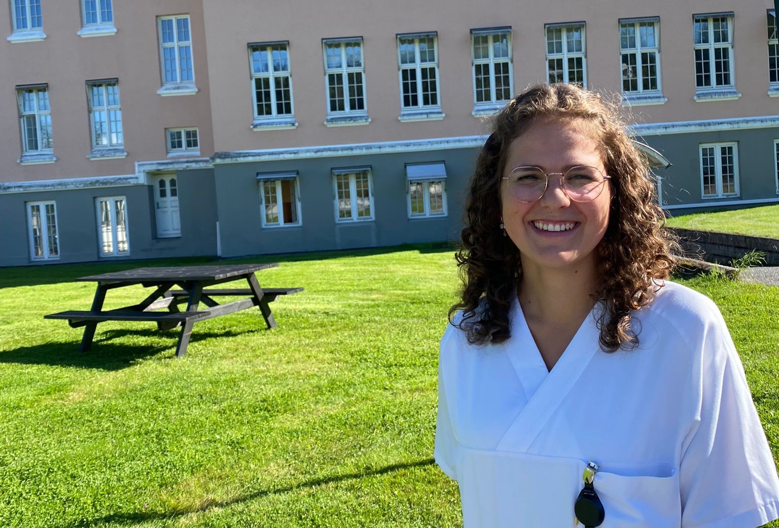 En av de ansatte står foran et av sykehusbyggene