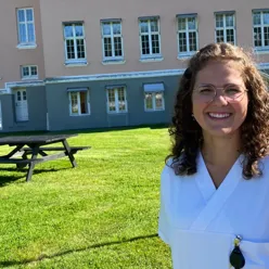 En av de ansatte står foran et av sykehusbyggene