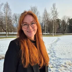 En av de ansatte står ute i naturen