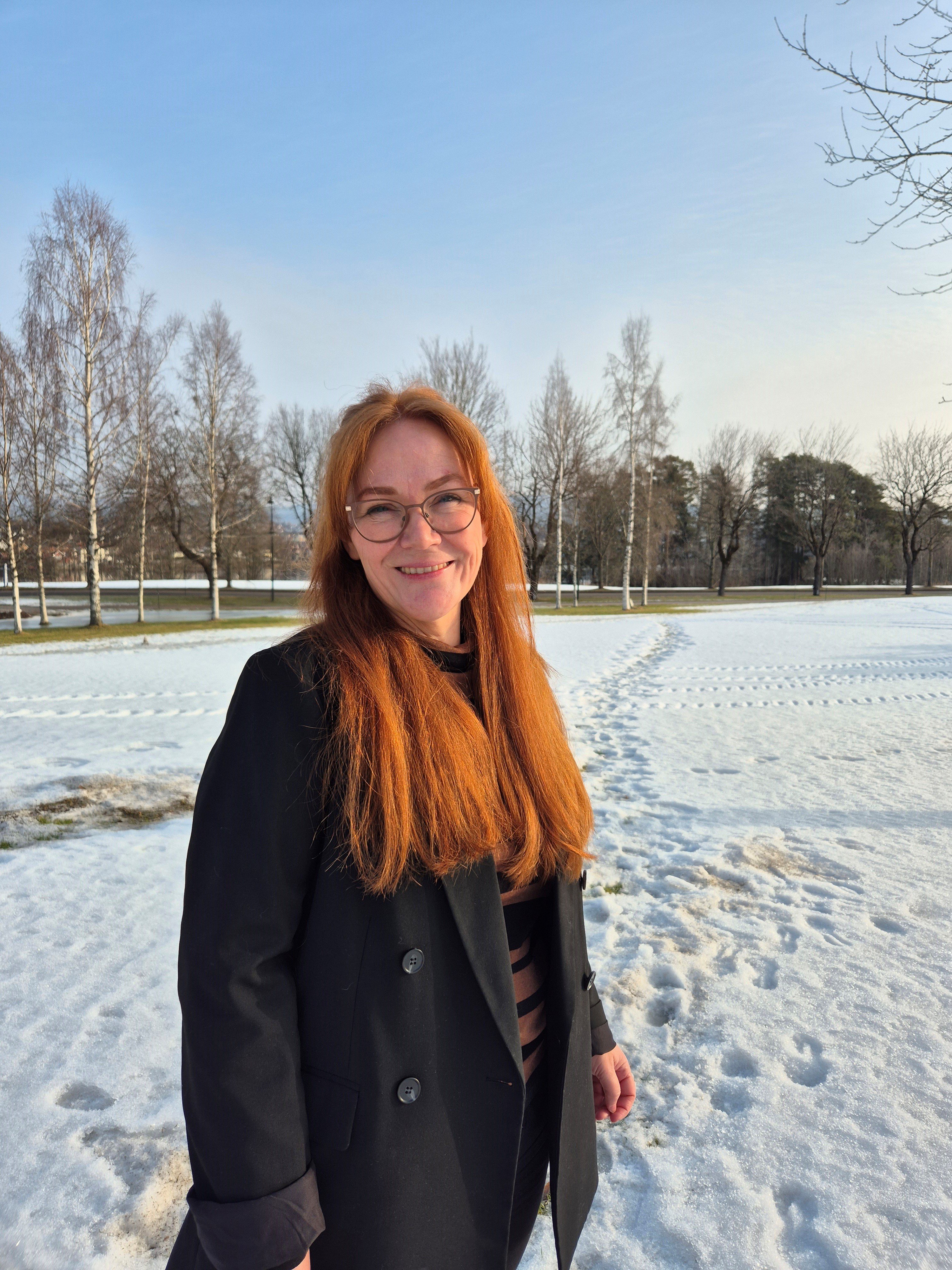 En kvinne som står på en snødekt eng