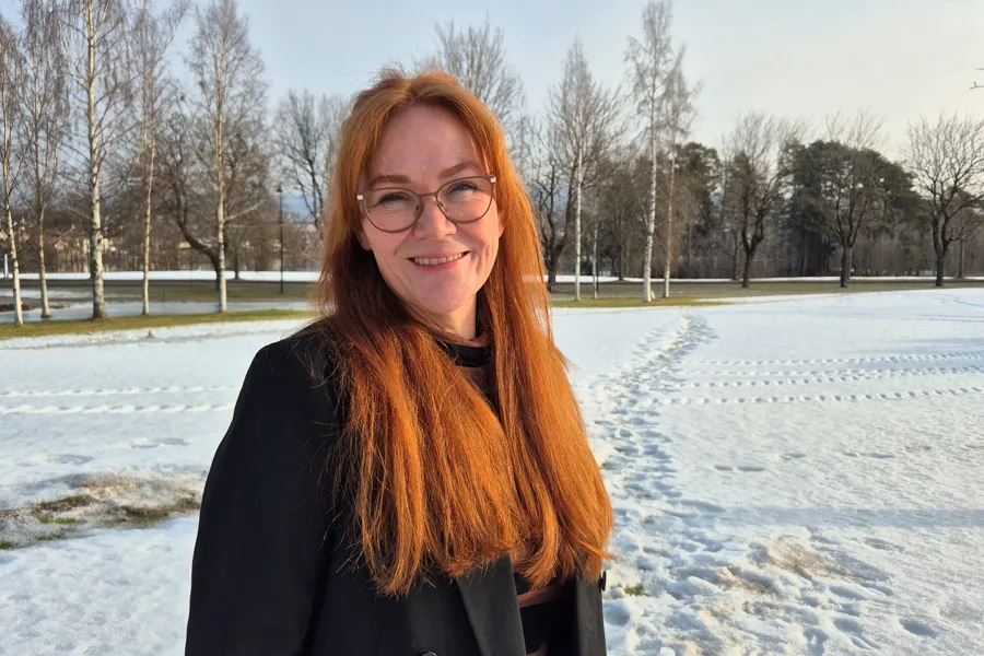 En kvinne som står på en snødekt eng
