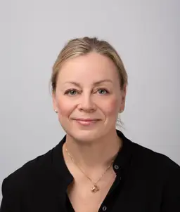 En kvinne som smiler til kameraet