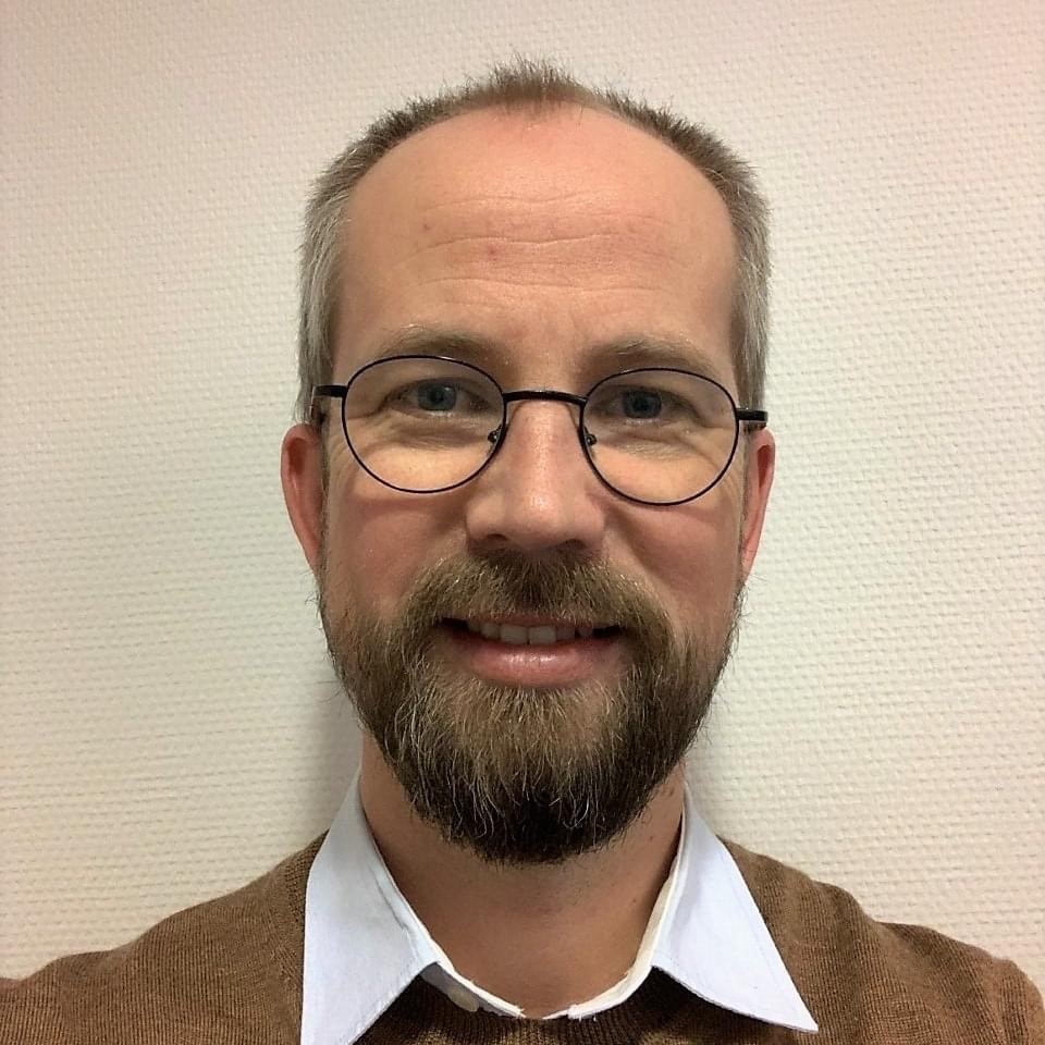 En mann med skjegg og briller