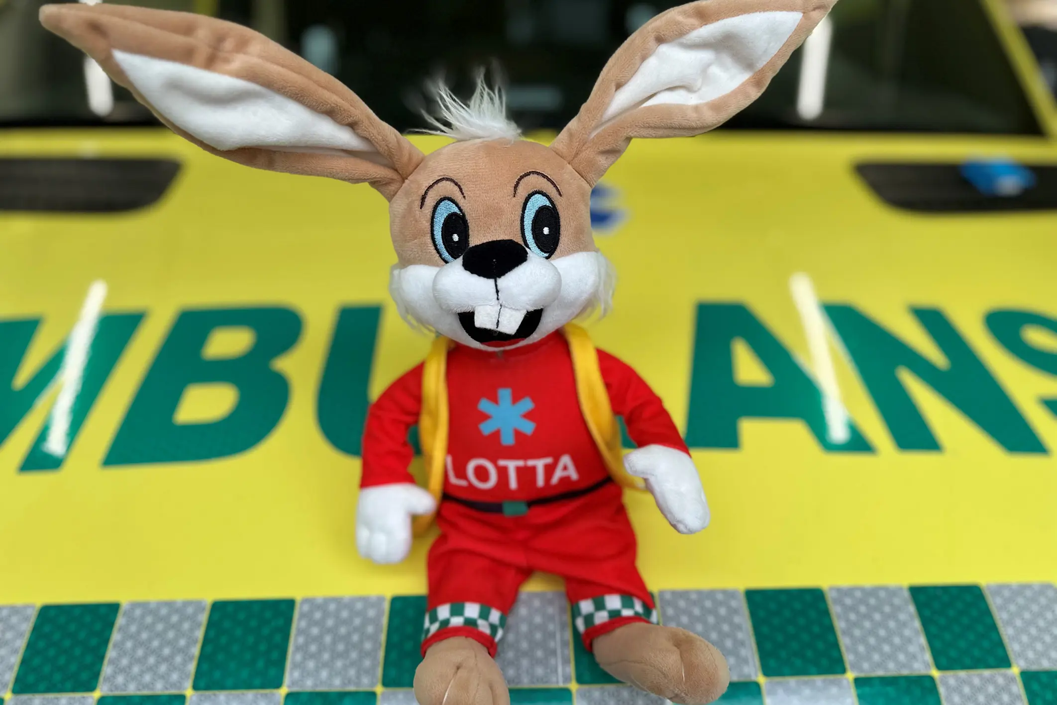 Maskoten Ambulotta sitter på en ambulanse