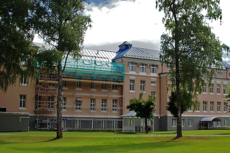 En stor bygning med trær foran seg