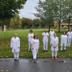 A group of people in white uniforms walking on a path
