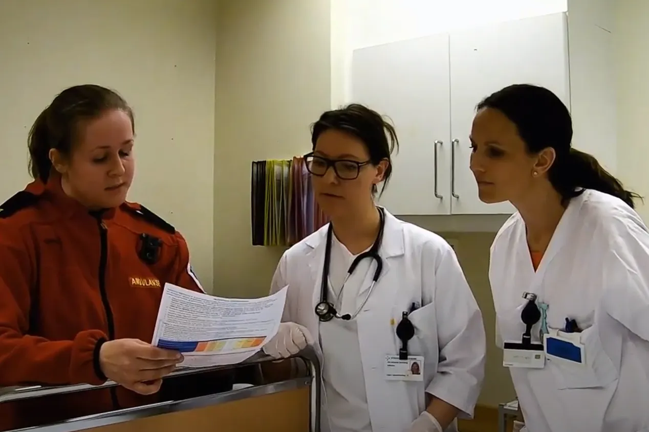 ambulansearbeider i samtale med to sykepleiere