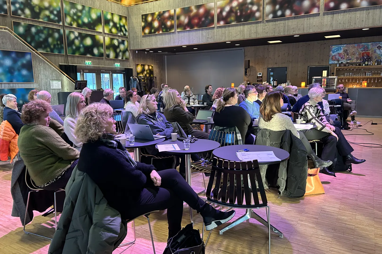 En gruppe mennesker som sitter ved bord