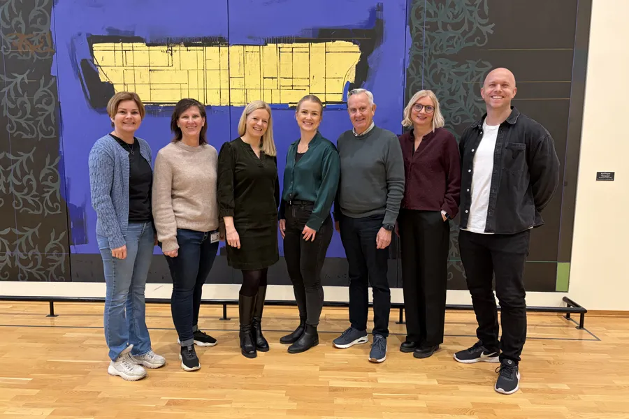 Bilde av syv i nettverket foran en vegg inne på sykehuset