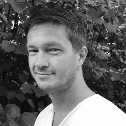 En mann som smiler til kameraet