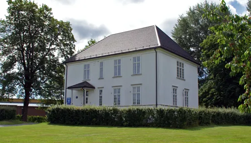 Et hvitt hus med en plen foran seg