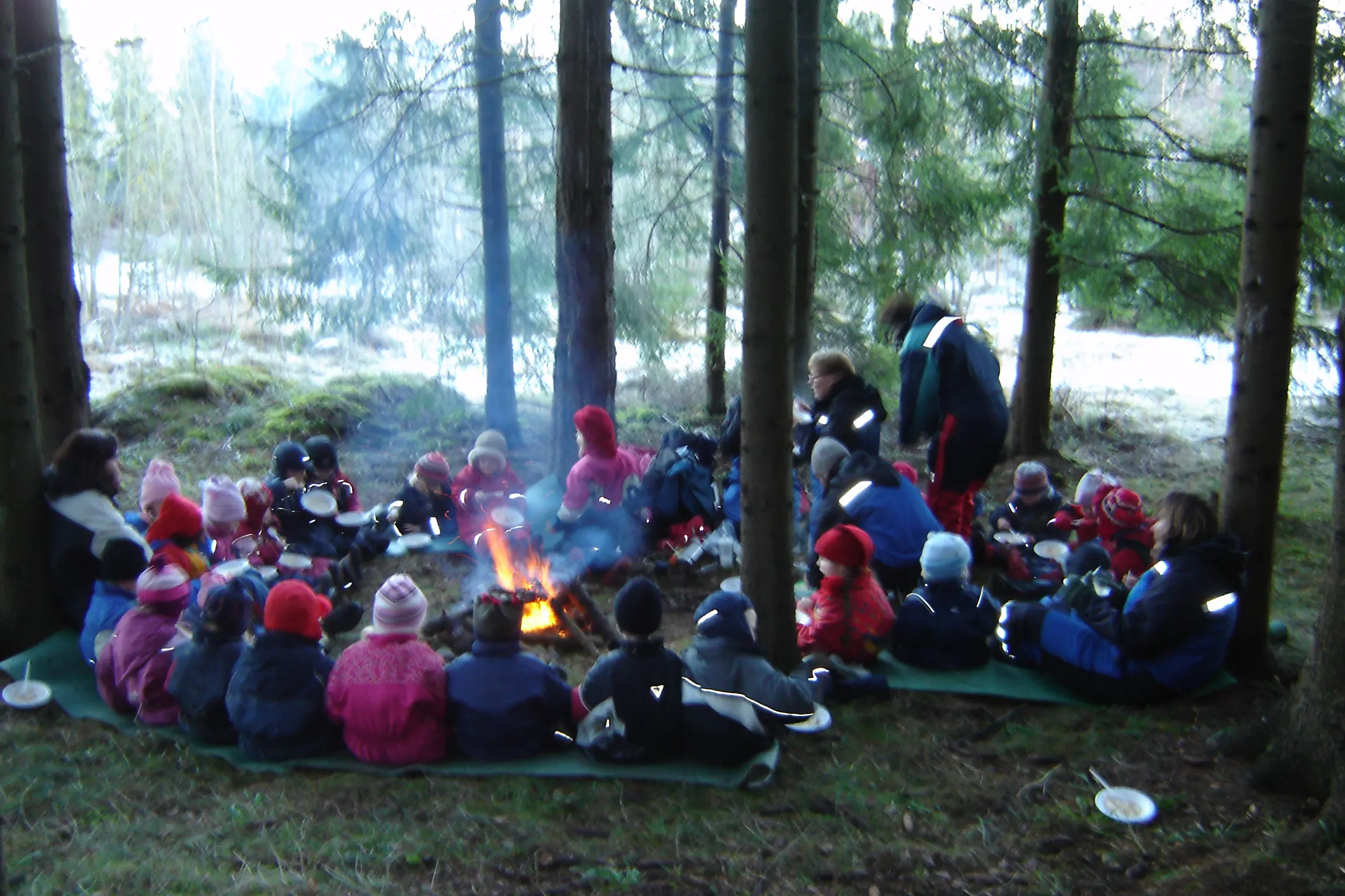 En gruppe mennesker som sitter i skogen